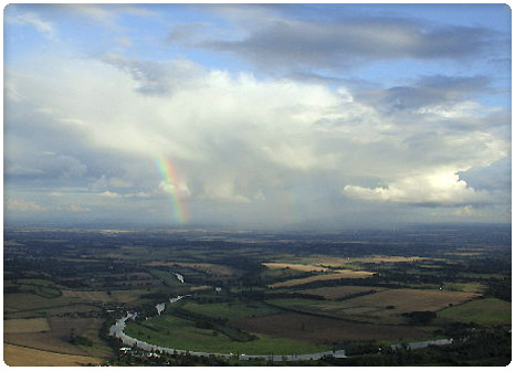 Rainbow and clouds over a river from a hot air balloon